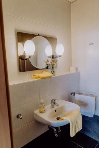 a bathroom with a sink and a mirror at LandHotel in Altlandsberg
