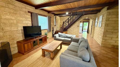 a living room with a couch and a flat screen tv at Timber Tides Retreat in Geographe
