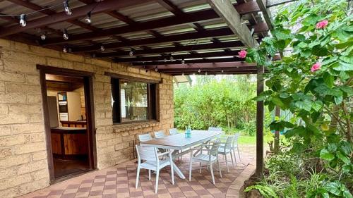 a patio with a table and chairs under a pergola at Timber Tides Retreat in Geographe