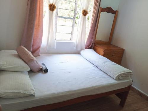 a bed in a room with a window at Tympang Chalet Home Stay in Dawki