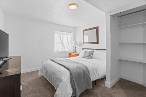 a white bedroom with a bed and a television at Modern Private Whole Unit 4 Bedroom Guest Suite King Bed in Salt Lake City