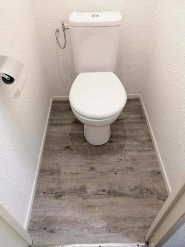 La salle de bains est pourvue de toilettes blanches et de parquet. dans l'établissement L'Aiguille - maeva Home - 2 Pièces 5 Personnes - Sélection MAE-4175, à Chamonix-Mont-Blanc