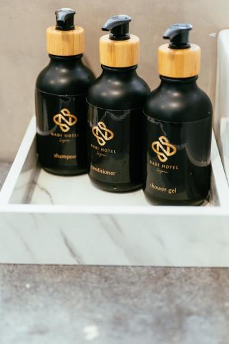 a shelf with three black bottles on it at Nadi Hotel Legian in Legian