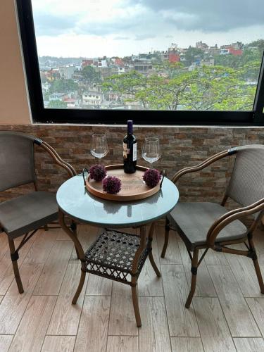 a table with a bottle of wine and two chairs at Casa Velodromo in Xalapa