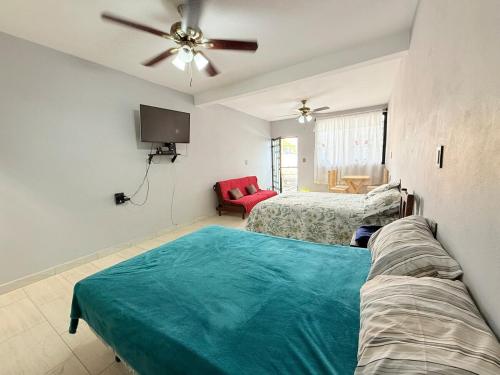 a bedroom with two beds and a ceiling fan at El Rinconcito Oaxaca - HiveNB in Santa Cruz Xoxocotlán
