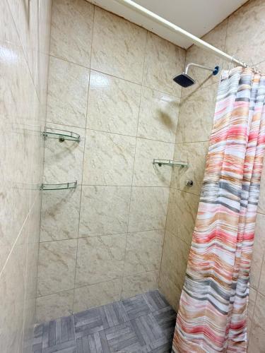 a shower with a shower curtain in a bathroom at El Rinconcito Oaxaca - HiveNB in Santa Cruz Xoxocotlán