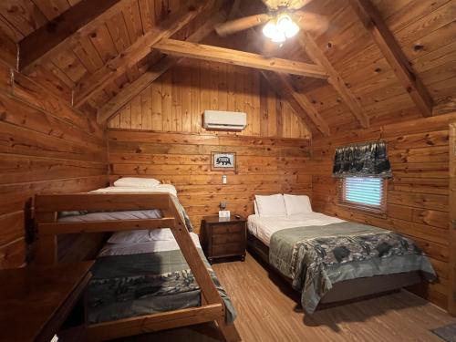 a bedroom with two beds in a log cabin at Homey Cabin with Mountain Views in Pigeon Forge