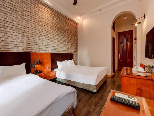 Postel nebo postele na pokoji v ubytování Super OYO Capital O 1173 Le Grand Hanoi Hotel - The Ruby
