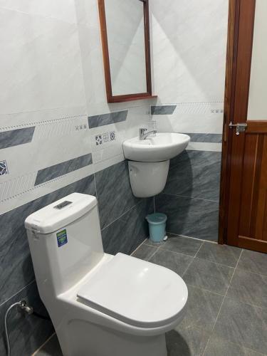 a bathroom with a toilet and a sink at Nhà Nghỉ NHẬT TIÊN in Tân Phú