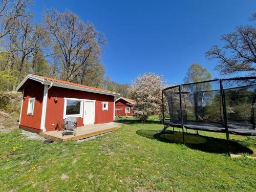 a small house with a basketball hoop in a field at Sauna&Jacuzzi-New guesthouse, private in nature in Vallda