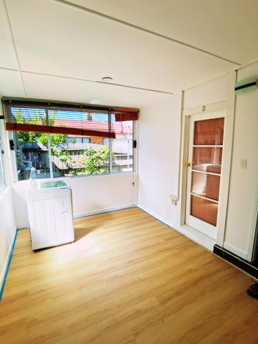 an empty room with a wooden floor and a large window at Regent Residential House in Whangarei