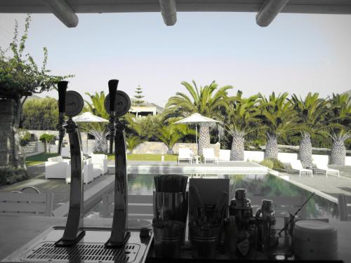 a table with wine bottles on it next to a pool at Roses Beach in Parikia