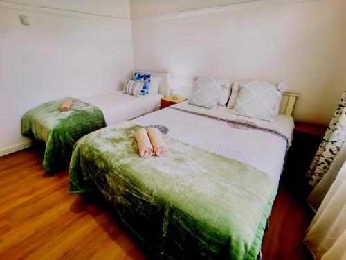a bedroom with two beds with slippers on them at Regent Residential House in Whangarei
