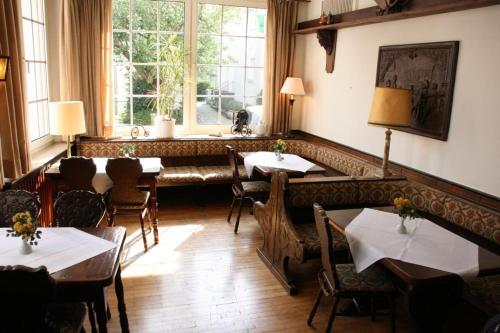 ein Esszimmer mit Tischen, Stühlen und einem Fenster in der Unterkunft Hotel Diening in Essen