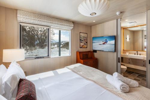 a bedroom with a bed and a tv in it at The Stables Resort Perisher - Open All Year in Perisher Valley