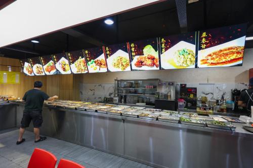 a man is standing at a counter in a restaurant at 5mins to Sunway Pyramid #Subang SS15 Cozy Studio Menara Rajawali in Subang Jaya