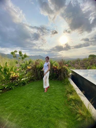 a person standing on the grass on a roof at Sumberkima Resort in Pemuteran