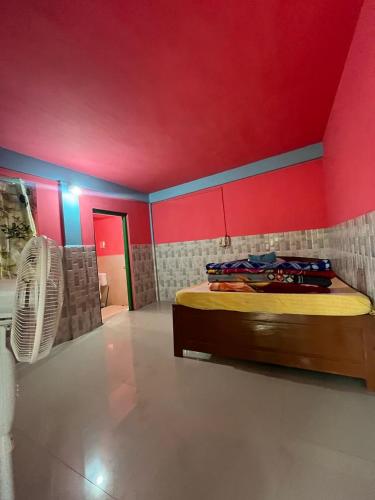 a room with a bed and a red wall at Skhem Home Stay Shnongpdeng in Dawki