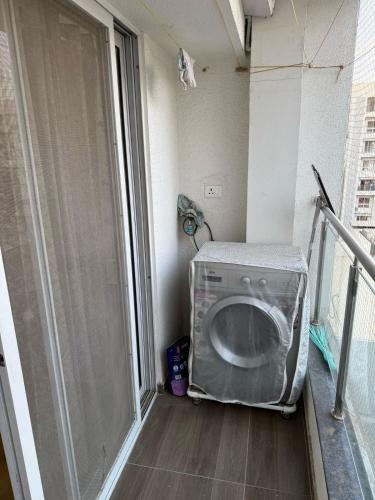 a laundry room with a washing machine on a balcony at Luxe 3bhk bungalow Baner in Pune