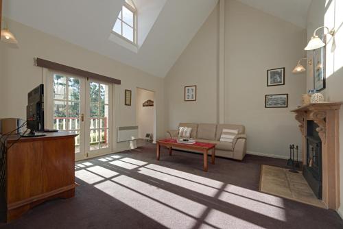a living room with a couch and a fireplace at CRABTREE RIVERFRONT COTTAGES 2 cottages EMILY & ELIZA COTTAGES Beautiful riverfront peaceful location RELAX & ENJOY in Huonville