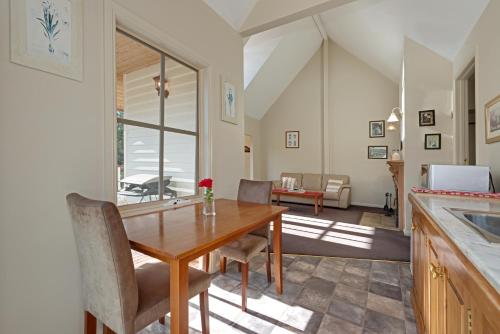 a kitchen and dining room with a table and chairs at Crabtree Riverfront Cottages - Riverfront Relaxation in Grove