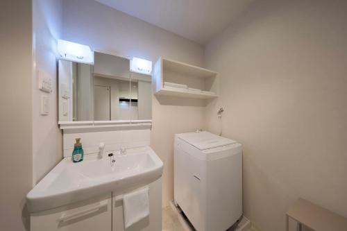 a bathroom with a sink and a white refrigerator at クリスタルコート白浜 in Shirahama