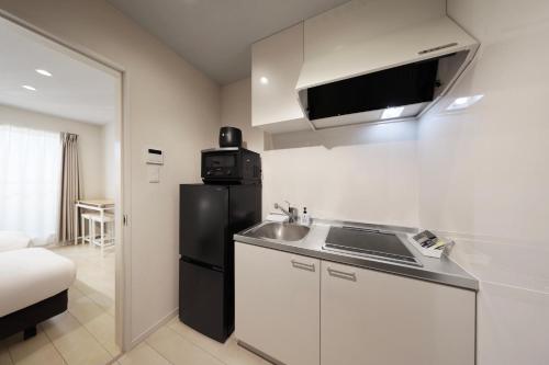 a small kitchen with a sink and a refrigerator at クリスタルコート白浜 in Shirahama