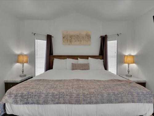 Un dormitorio con una gran cama blanca con dos lámparas. en Studio Model Home with Parking, en Pigeon Forge