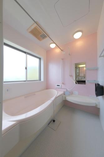 a white bathroom with a tub and a sink at Villa Lotus in Kamakura