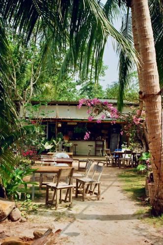 a group of wooden tables and chairs in a garden at Sand and Sea Koh Kood in Ko Kood