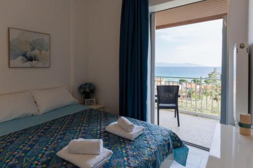 a bedroom with a bed and a view of the ocean at Sea Zen in Paleo Tsifliki