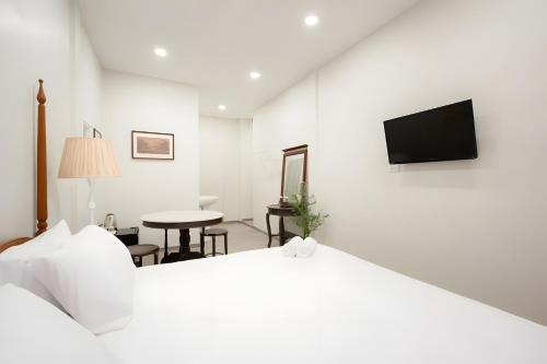 a white room with a bed and a table at xxCASA Dragon Yaowarat - MRT วัดมังกร in Samphanthawong