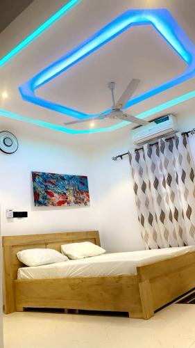 a bedroom with a bed and a ceiling with blue lights at Residence The Champion 2 in Ouidah