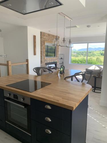 a kitchen with a island with a wooden counter top at Luxury Cottage, views of the Lakes with Hot Tub in Cockermouth