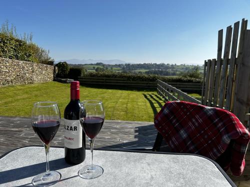 two glasses of red wine sitting on a table at Luxury Cottage, views of the Lakes with Hot Tub in Cockermouth