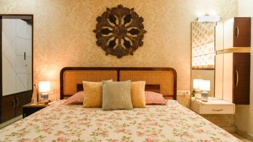 a bedroom with a bed with pillows and a clock on the wall at Luho 6 off Sarjapur Road in Bengaluru