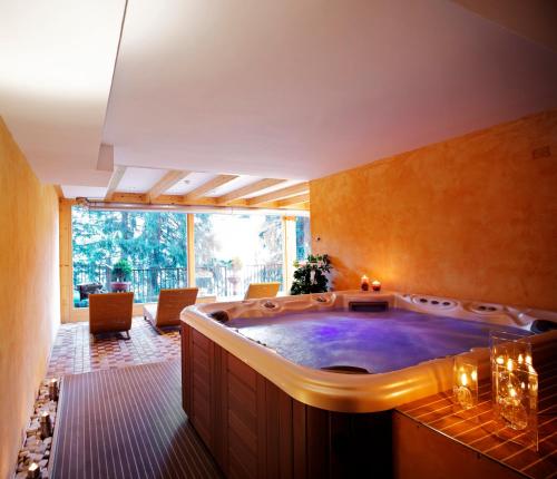 a large bathroom with a large hot tub at Hotel Caminetto in Folgarida