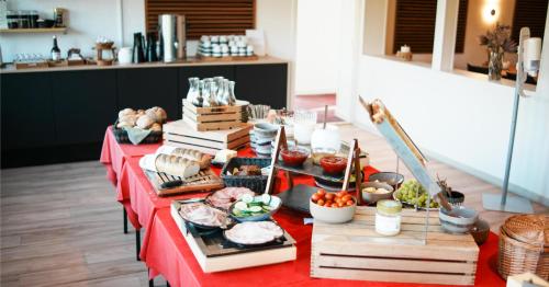 a long table with food on a red table at Hotel Falken in Videbæk