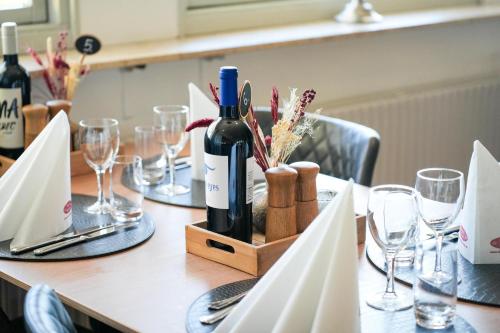 a table with a bottle of wine and glasses at Hotel Falken in Videbæk