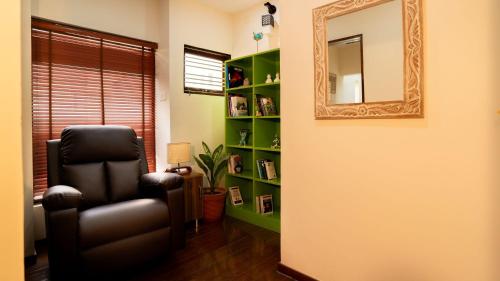 a living room with a chair and a mirror at Luho 6 off Sarjapur Road in Bengaluru