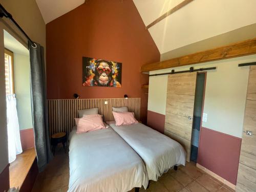 une chambre avec un grand lit avec des oreillers roses dans l'établissement Domaine de Collen, à Lépine