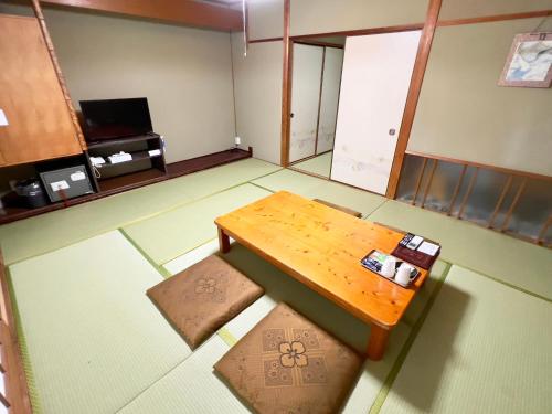 Higashi-komi国民宿舎古岩屋荘的空房间,配有木桌和凳子
