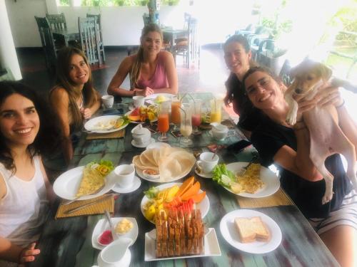 een groep mensen die rond een tafel zitten met eten bij Hungry Lion Sigiriya in Sigiriya