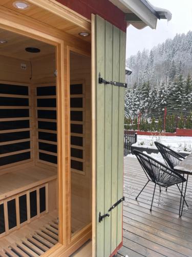 a screened in porch with a table and chairs on a deck at Wioska w Sowich Sokolec in Sokolec