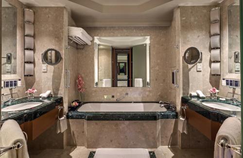 a bathroom with two sinks and a bath tub at The Peninsula Bangkok in Bangkok
