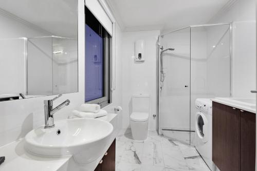 a white bathroom with a sink and a shower at Attika Hotel in Perth