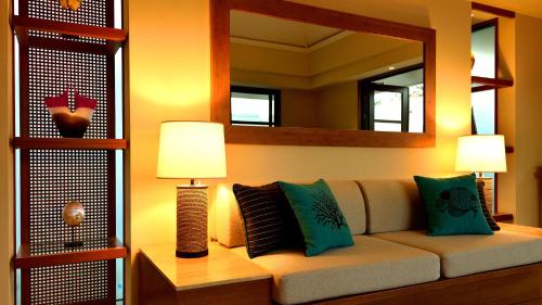 a living room with a couch and a mirror at The Uza Terrace Beach Club Villas in Yomitan