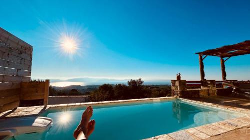 a person laying on the edge of a swimming pool at Cassiopea Guest House Evia Greece in Nerotriviá