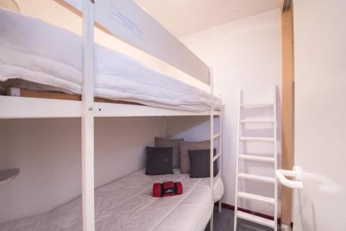 - une chambre avec 2 lits superposés et un sac à dos rouge dans l'établissement Appartement plein centre quartier des thermes, à Saint-Lary-Soulan