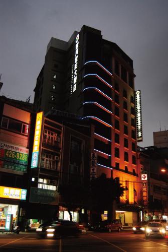 a building on a city street at night with cars at Century Hotel Taoyuan in Taoyuan